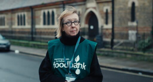 En kvinna med en väst som det står "Food bank" på.